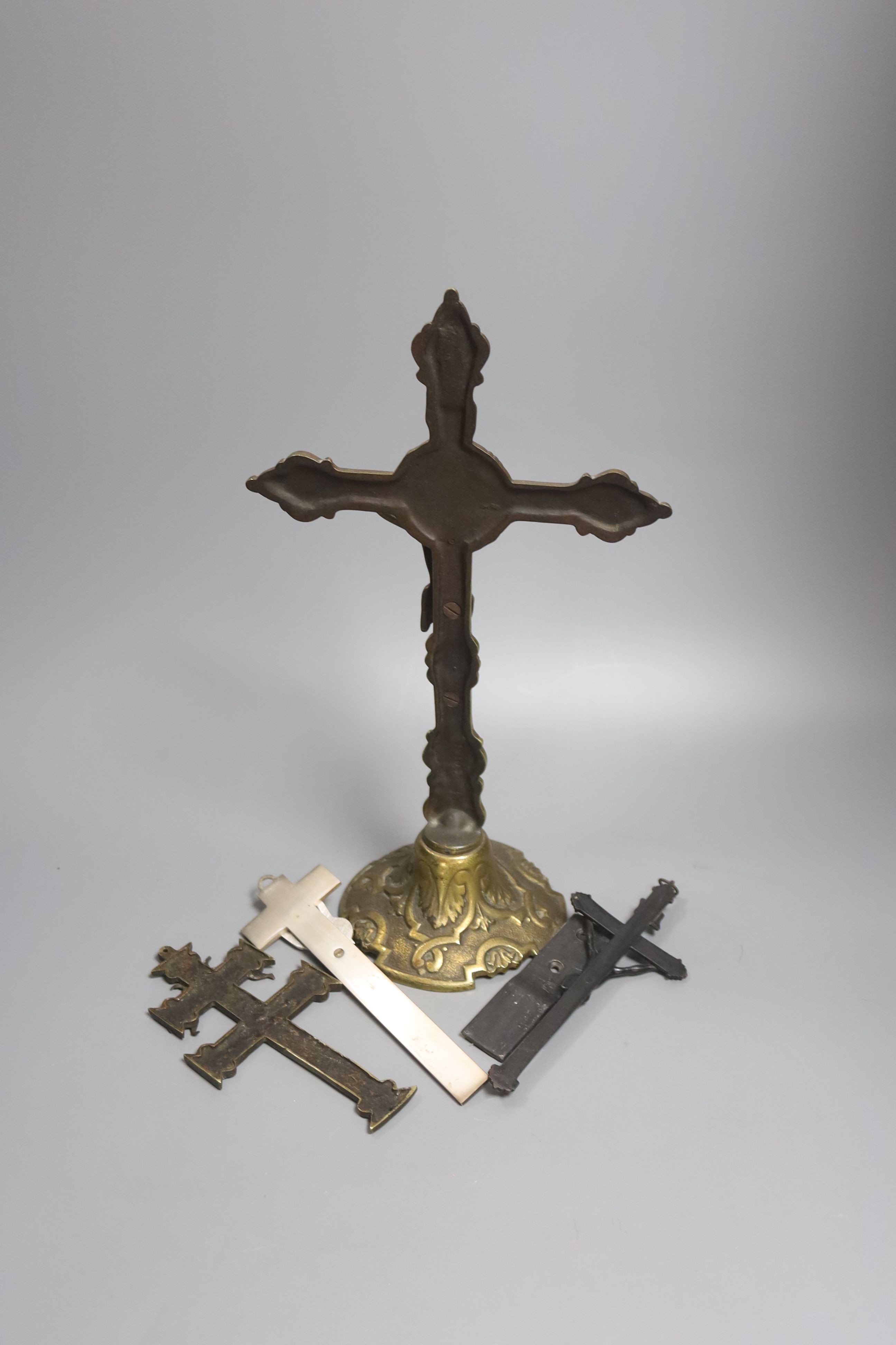 A group of four brass and metal crucifixes, largest 34cm